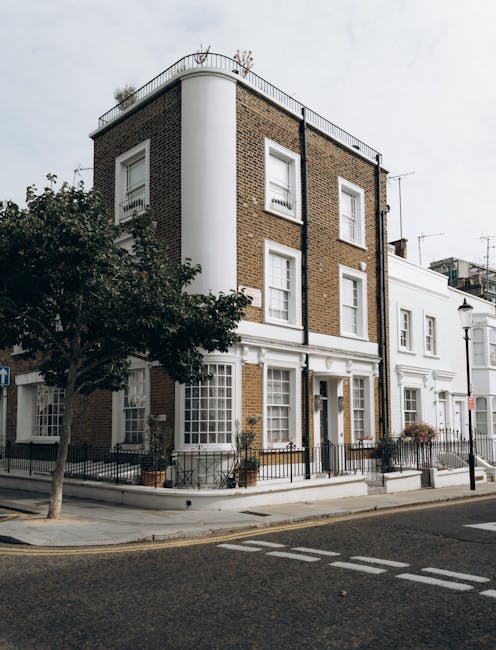 The image shows the front entrance of a residential property on Pembridge Road, featuring a maroon-painted wooden front door with a gold handle and letter slot, positioned within a white decorative do